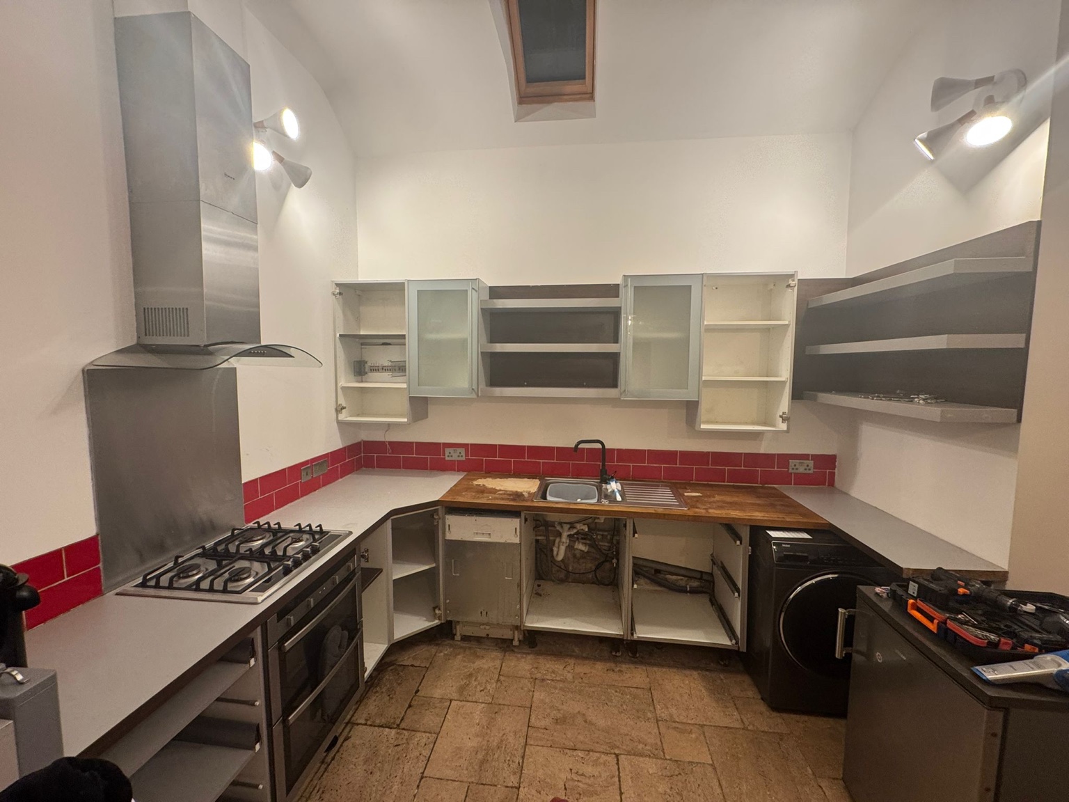 Earlier kitchen with red tiles and cabinetry partly removed