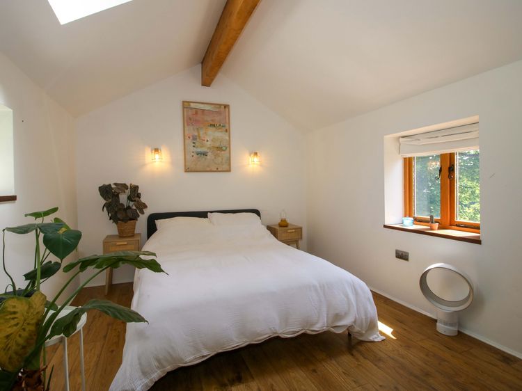 Light bedroom with vaulted ceiling and timber beam