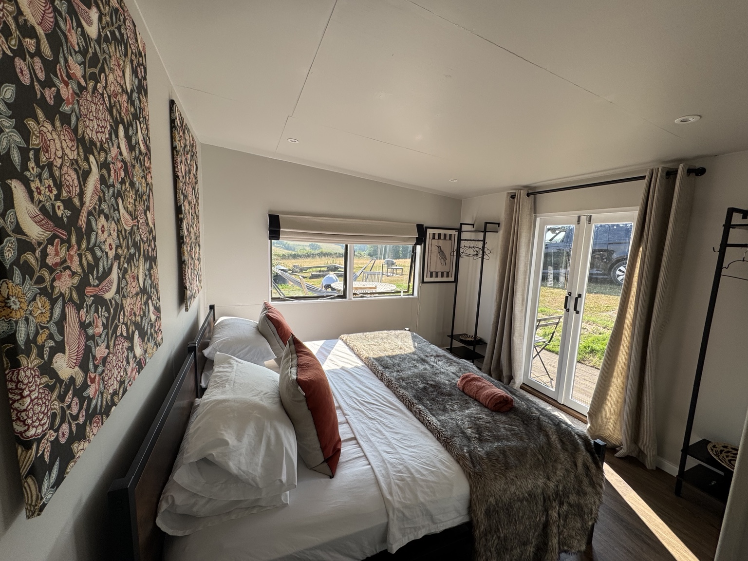 Guest bedroom with neutral walls and garden views