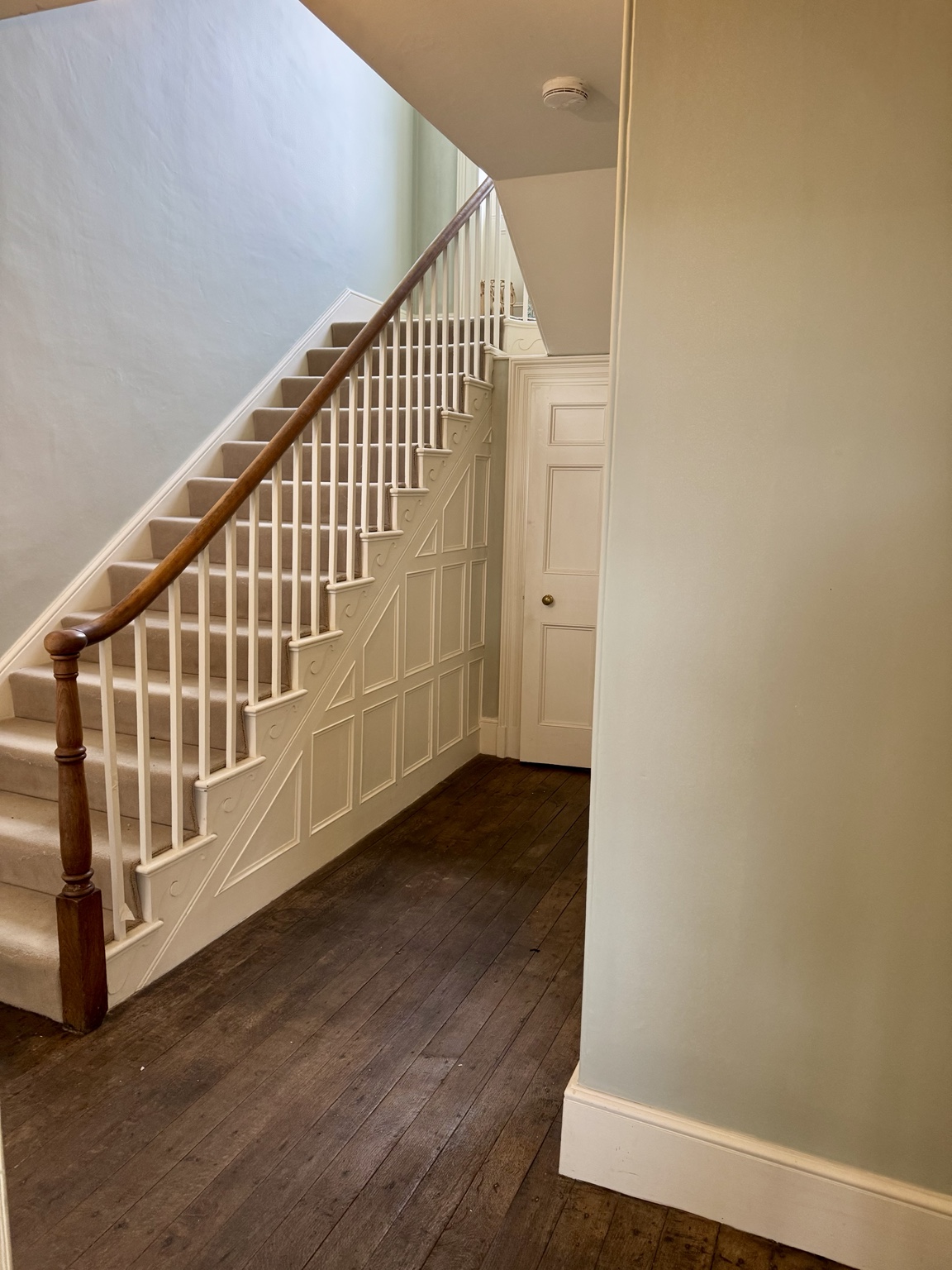 Staircase after, with light walls, white balusters and timber handrail